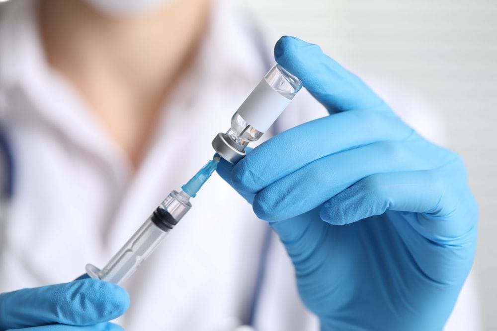 A doctor prepares to administer peptide therapy injection