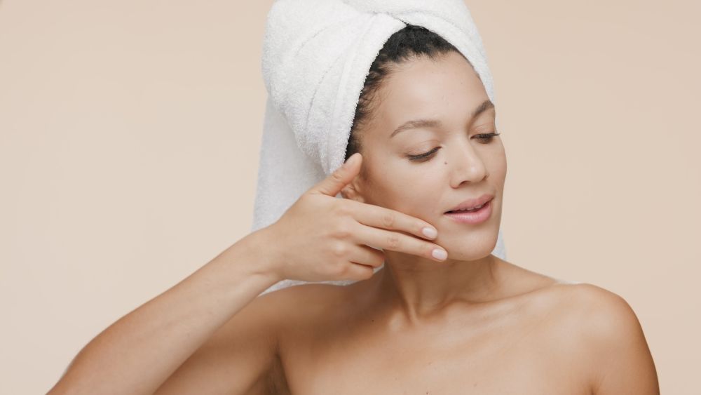 A woman checking her jawline after v shape face treatment