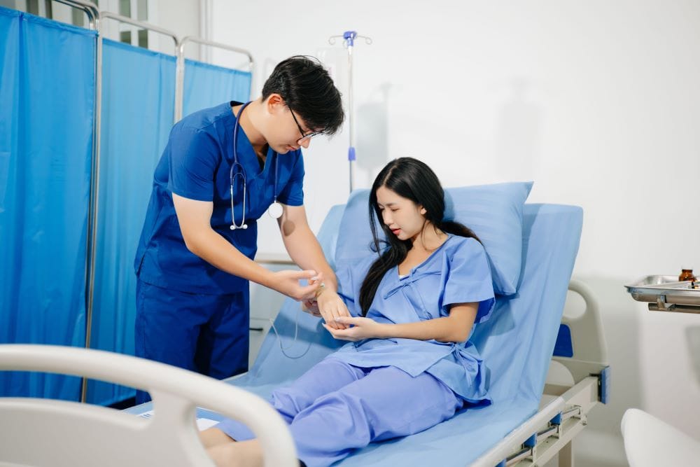 A doctor administering an IV drip to a female patient as part of one of the IV therapy packages.