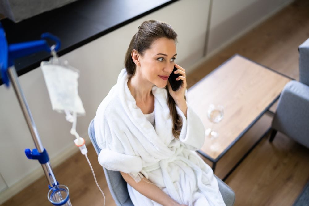 A woman receiving IV drip therapy as part of a longevity medicine protocol at a wellness clinic.